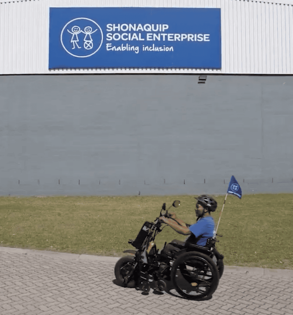 Rider on a NeoMotion powered wheelchair attachment at Shonaquip Social Enterprise